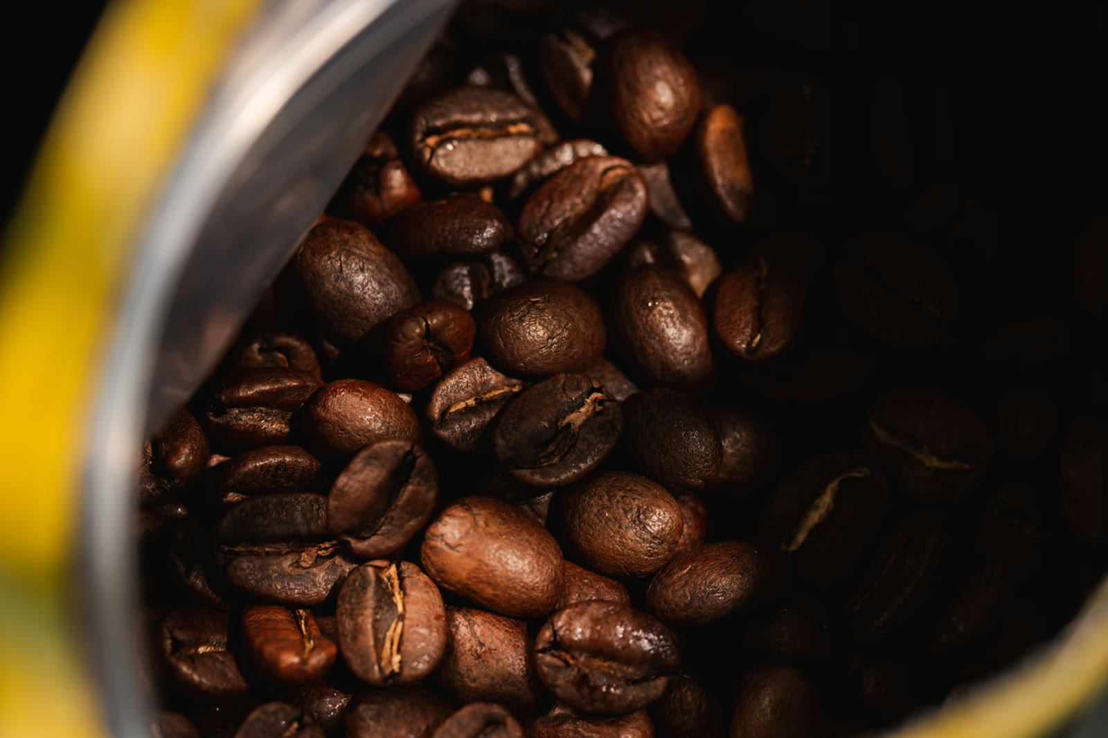 Whole roasted coffee beans in an open bag